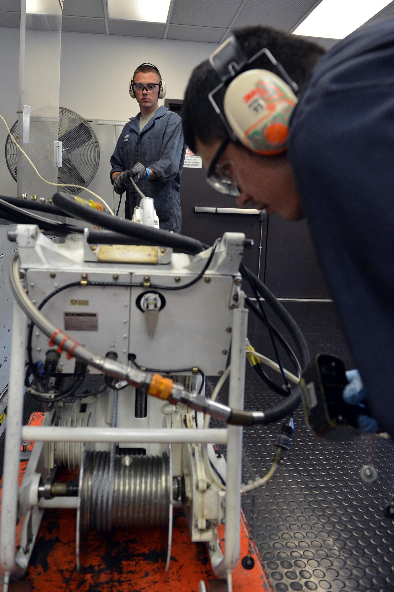 Airman 1st Class Sean Thompson, 62nd Maintenance Squadron hydraulics technician (left), and Tech Sgt. Ron Capalungan, 446th Maintenance Squadron hydraulics technician (right), replace the cable on a cargo winch, July 30, 2013, at Joint Base Lewis-McChord, Wash. McChord hydraulics technician’s regularly perform major overhauls to C-17 Surge protectors, actuators and main landing gear brakes.      (U.S. Air Force photo/Airman 1st Class Jacob Jimenez)  