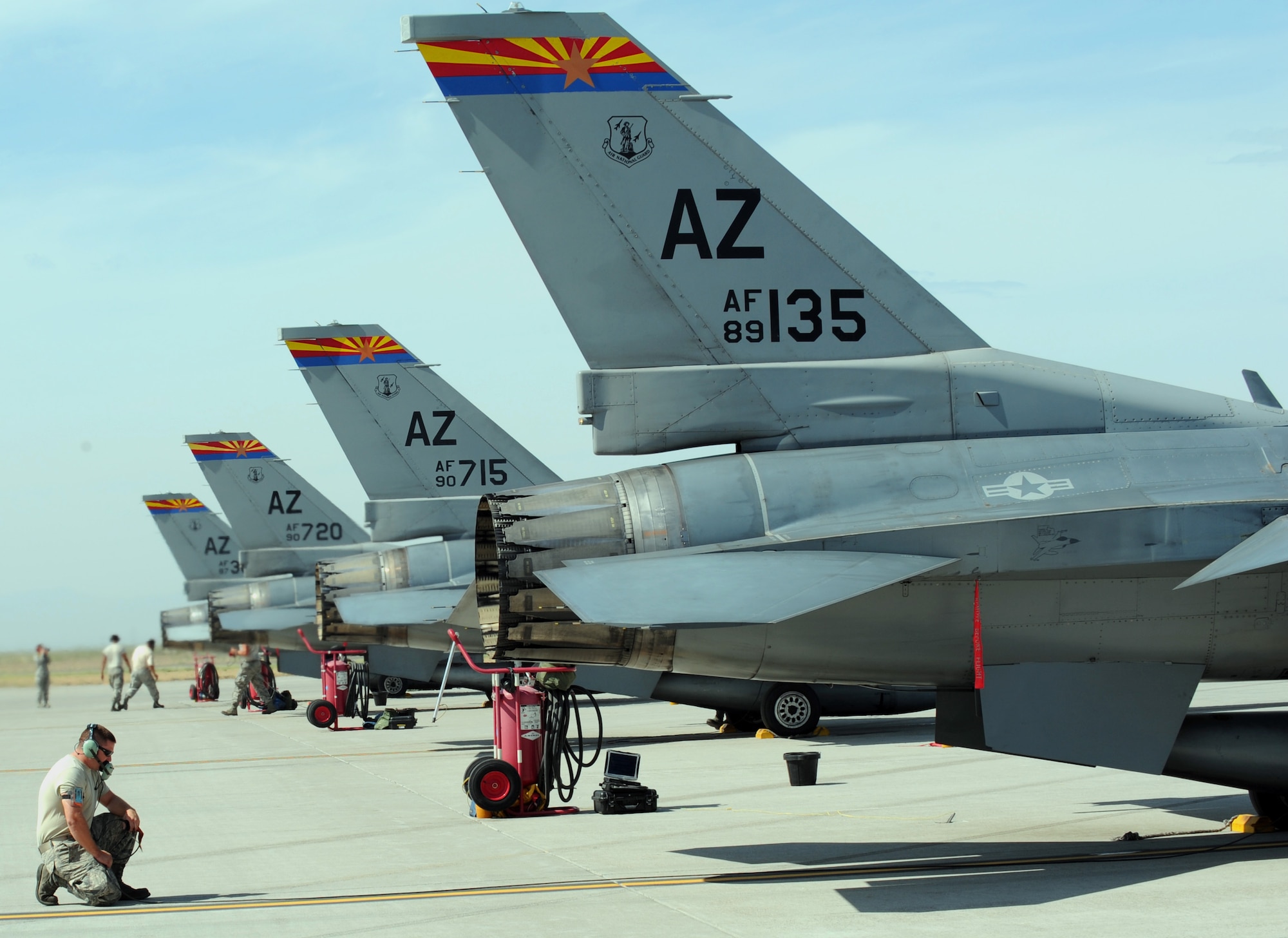 Staff Sgt. Rick Akers, 152nd Fighter Squadron crew chief, kneels on the flightline Aug. 22, 2013, at Mountain Home Air Force Base, Idaho. Arizona Air National Guardsman came here to utilize the available runway space in order to train students on the F-16 Fighting Falcon. (U.S. Air Force photo by Senior Airman Benjamin Sutton/Released)