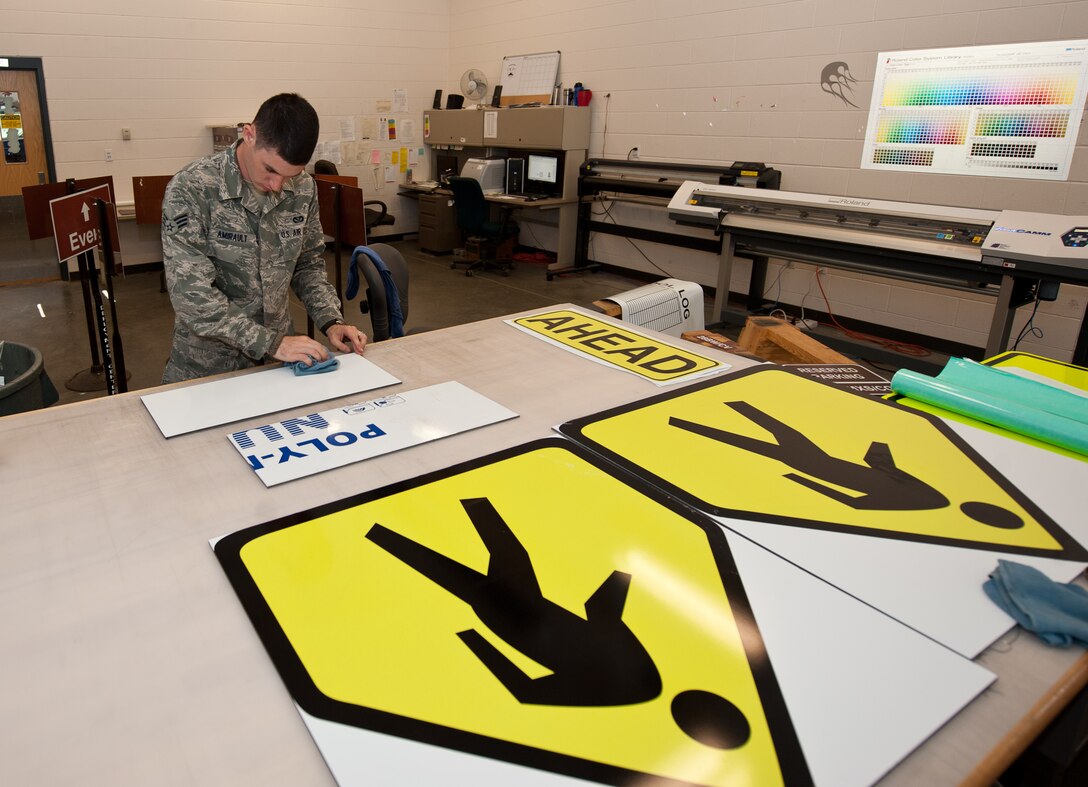 Senior Airman Benjamin Amirault, 28th Civil Engineer Squadron structures technician, washes poly-metal prior to adhering a printed sign at Ellsworth Air Force Base, S.D., Aug. 15, 2013. Airmen of the 28th CES sign shop produce approximately 720 signs per year to supply Ellsworth with road, building, and safety markings. (U.S. Air Force photo by Airman 1st Class Alystria Maurer/Released)