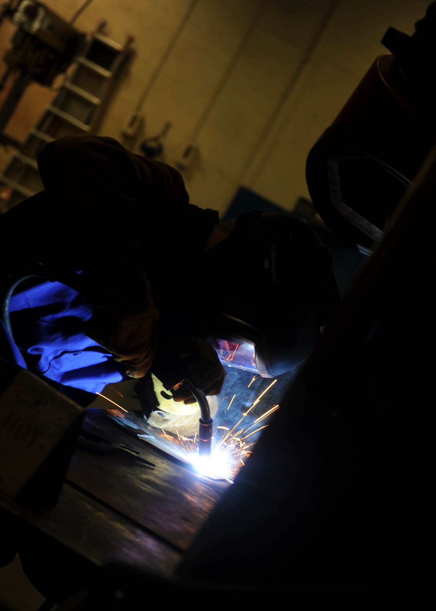 Airman 1st Class Joshua Soucy, 28th Maintenance Squadron aircraft metals technician, welds metal sheets together at the welding shop on Ellsworth Air Force Base, S.D., Aug. 15, 2013. When the sheets crack, they are welded back together to ensure their structural integrity, which also prevents the Air Force from having to buy an entirely new part. (U.S. Air Force photo by Airman 1st Class Anania Tekurio/Released)  