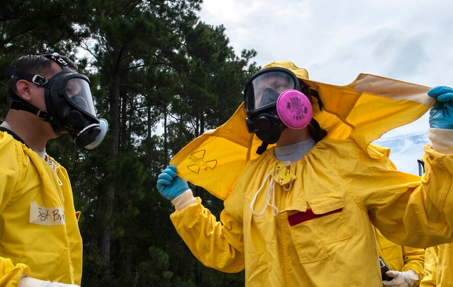 U.S. Air Force Airman 1st Class Bryana Hodge, 23d Medical Group bioenvironmental engineering technician, removes the hood from her radiation suit after it was tested for radiation during a nuclear weapons incident exercise at Moody Air Force Base, Ga., Aug. 16, 2013. The decontamination station is there to prevent the possible spread of radiation to other areas.(U.S. Air Force photo by Airman 1st Class Sandra Marrero/released) 
