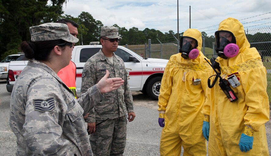 U.S. Air Force Tech. Sgt. Brandi Baker, 23d Civil Engineer Squadron NCO in charge of emergency management, gives a safety briefing to Senior Airman Justin Roberts (left), and Airman 1st Class Bryana Hodge (right), 23d Medical Group bioenvironmental engineering technicians, during a nuclear weapons incident exercise at Moody Air Force Base,  Ga., Aug. 16, 2013. The technicians received the briefing prior to passing through an entry-control point to sample the air for alpha, beta and gamma radiation. (U.S. Air Force photo by Airman 1st Class Sandra Marrero/released)
