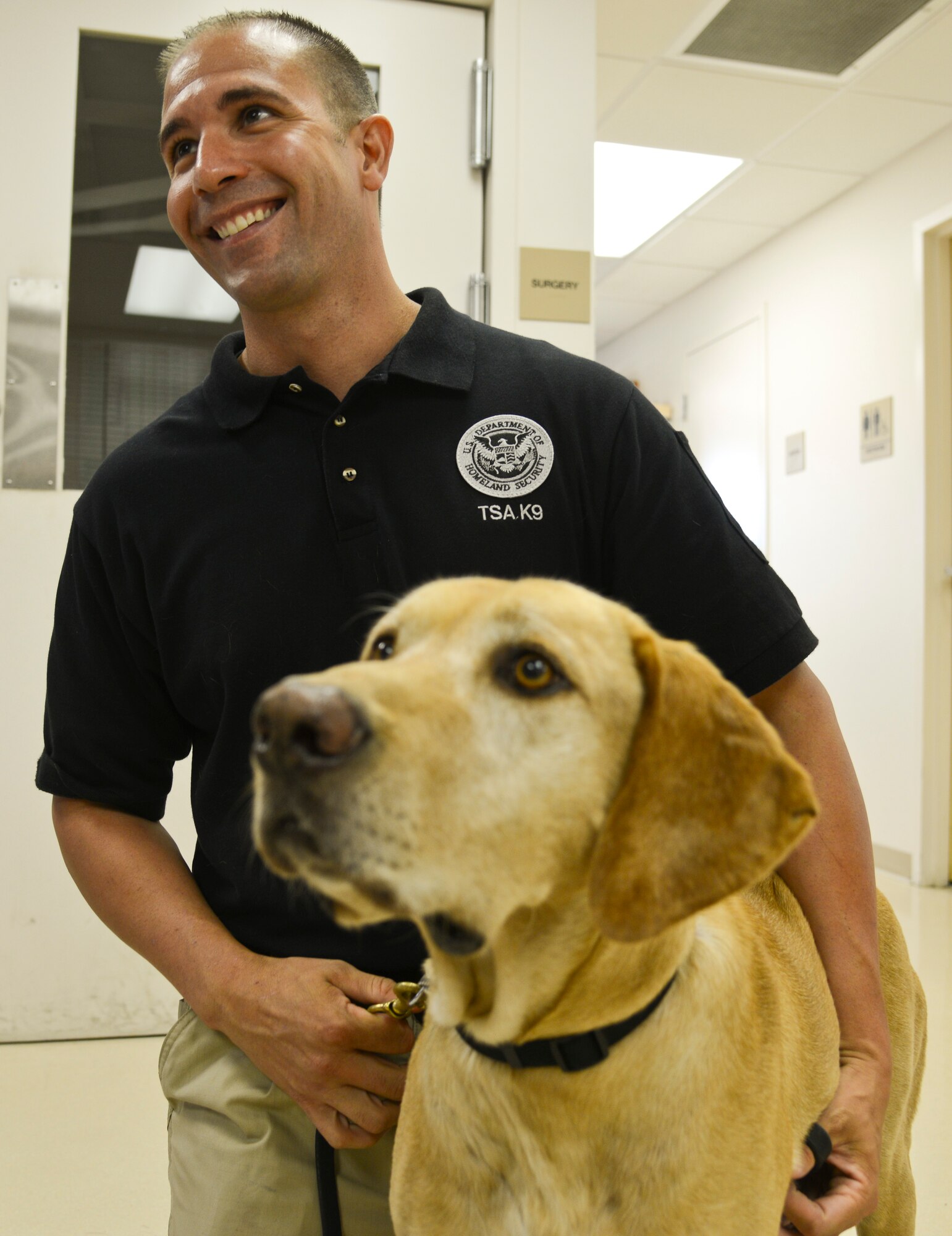 Kelsey King, a Transportation Security Administration (TSA) inspector assigned to the Tampa International Airport, and Jimmy, a TSA explosives detection K-9, have a quick meet-and-greet with the doctor before Jimmy’s 6-month check-up at the Veterinary Treatment Facility at MacDill Air Force Base, Fla., Aug. 21, 2013. The 6-month check-up ensured that Jimmy was healthy and able to perform his duties as best as possible. (U.S. Air Force photo by Airman 1st Class Ned T. Johnston/Released)