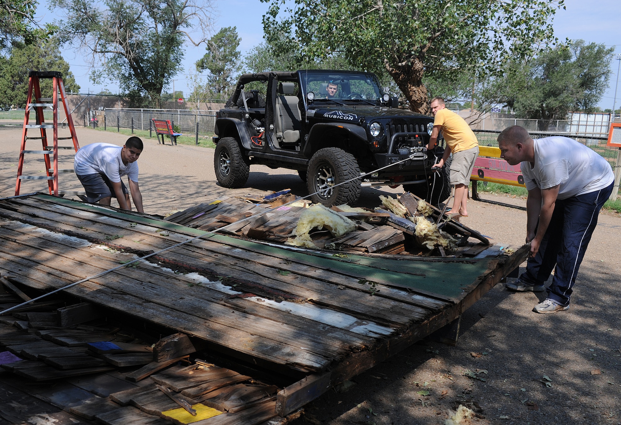 Members of the 27th Special Operations Aircraft Maintenance Squadron Booster Club tear down an outdated building Aug. 17, 2013, while volunteering at Hillcrest Park Zoo. The 27 SOAMXS Booster Club volunteers have spent many Saturday’s beautifying and improving the zoo. (U.S. Air Force photo/Senior Airman Ericka Engblom)