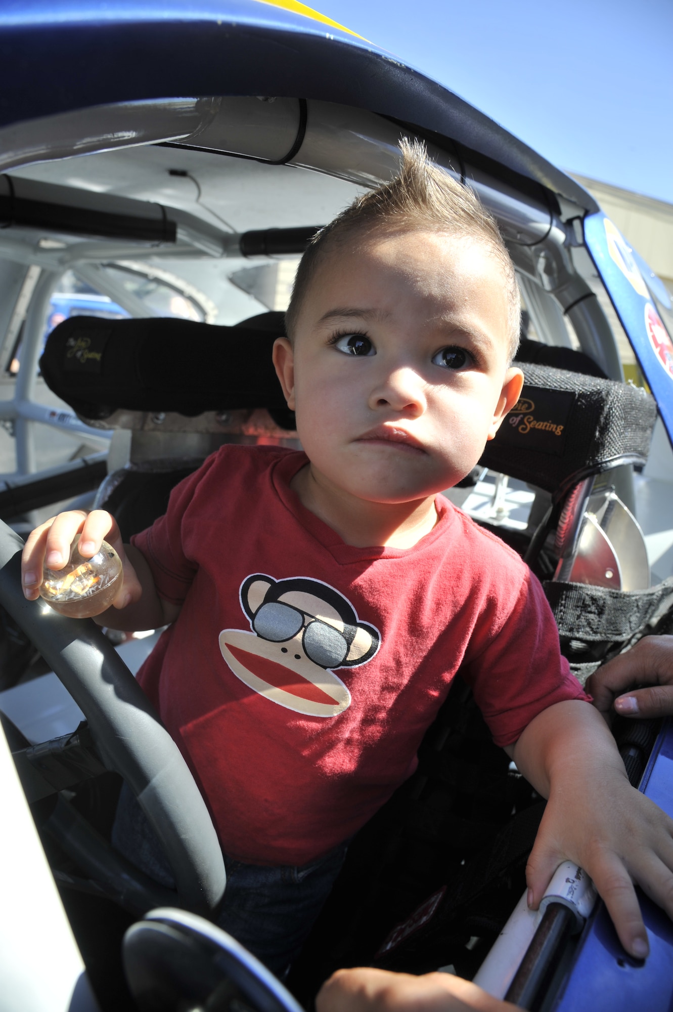 Zion Herrera, 1, sits in the No. 20 NAPA AUTO PARTS Toyota Camry at the Funspot at Fairchild Air Force Base, Wash., Aug. 21, 2013. Crew members from the Bill McAnally Racing Team gave away fifty free tickets to a local race in Airway Heights, Wash. (U.S. Air Force photo by Senior Airman Mary O'Dell/Released)