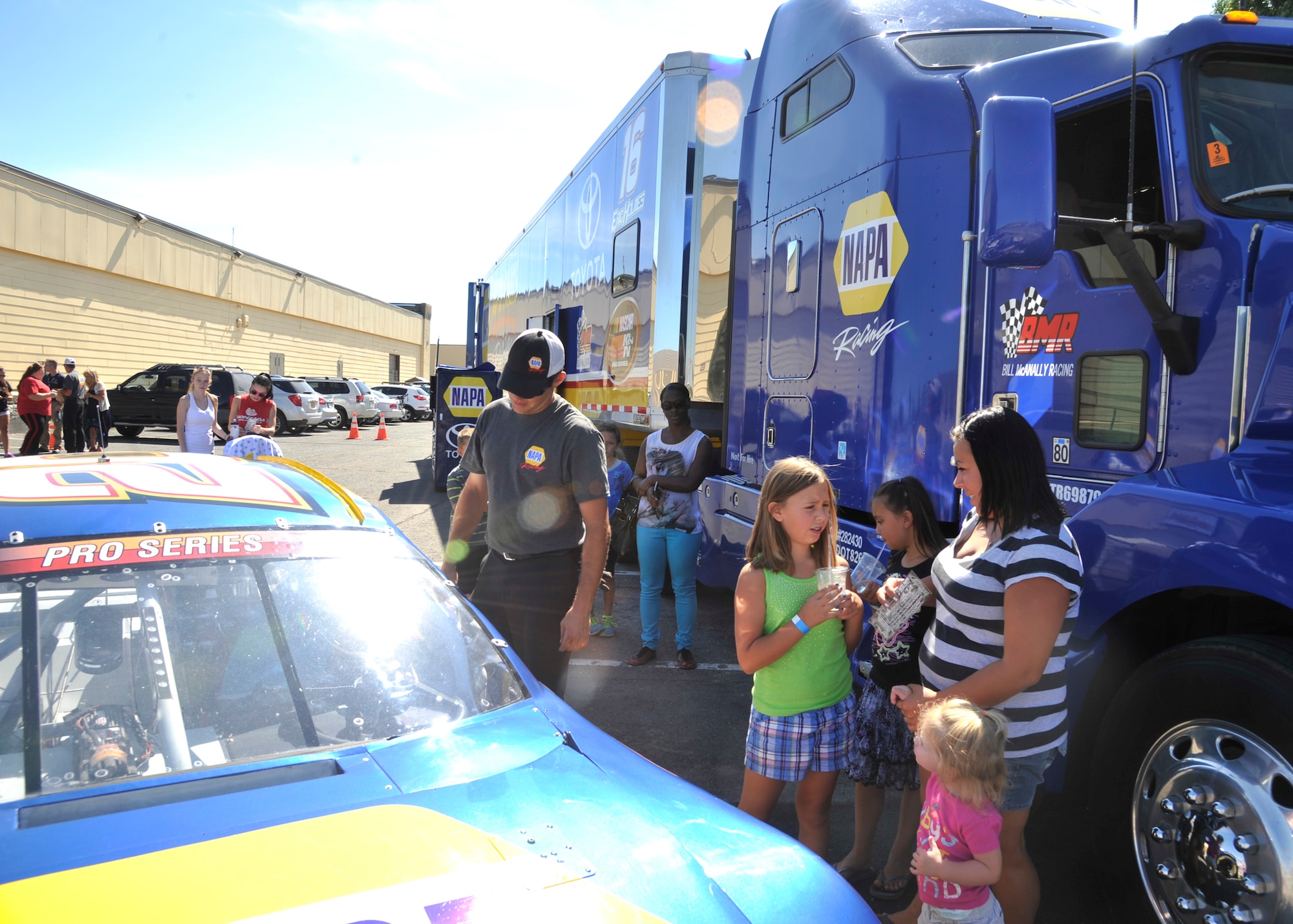 Members of Team Fairchild look around the No. 20 NAPA AUTO PARTS Toyota Camry and it's hauler truck at the Funspot at Fairchild Air Force Base, Wash., Aug. 21, 2013. Fifty free tickets to a local race were given away by the Bill McAnally Racing Team. (U.S. Air Force photo by Senior Airman Mary O'Dell/Released)