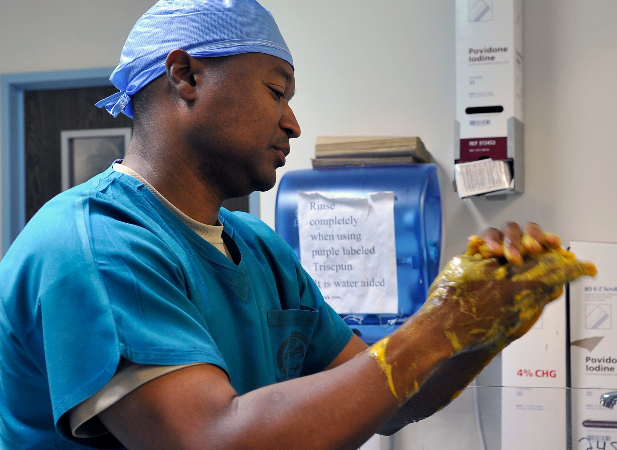 Chief Master Sgt. Anthony Kendrick , 86th Medical Group superintendent, scrubs his hands during a new versus old school challenge Aug. 22, 2013 at Landstuhl Regional Medical Center, Germany. The challenge was who could set tools up the quickest; an airman or the superintendant of the medical group. (U.S. Air Force photo/Senior Airman Trevor Rhynes)  