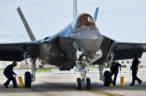 Sailors and Lockheed Martin personnel move in to chock the wheels of a Navy variant F-35C Lightning II after a sortie at Eglin Air Force Base, Fla.  The Sailors from the Strike Fighter Squadron-101, along with Airmen and Marines work directly with the LM maintainers to help put the joint strike fighters in the air.  (U.S. Air Force photo/Samuel King Jr.)
