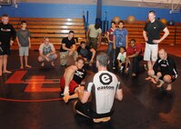 Steve Josephy, foreground, Armed Forces Entertainment Mixed Martial Arts Tour assistant tour director, gives remarks following an open training session with UFC fighters and celebrities Aug. 22, 2013, at RAF Mildenhall, England. Todd Duffee and Kyle Kingsbury, both UFC fighters, as well as Punka** and Skyskrape, co-founders of Tapout, visited the base to meet with Airmen and conduct a free training session.  (U.S. Air Force photo by Tech. Sgt. Neal X. Joiner/Released)