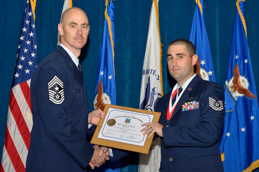 McGHEE TYSON AIR NATIONAL GUARD BASE, Tenn. - Tech. Sgt. Jeffrey C. Powell, right, from Shaw AFB, receives the distinguished graduate award for Noncommissioned Officer Academy Class 13-7 from Chief Master Sgt. Ronald C. Anderson, Jr., 1st Air Force (Air Forces Northern), Tyndall Air Force Base, Fla. here, Aug. 15, 2013. The distinguished graduate award is presented to students in the top 10 percent of the class.  It is based on objective and performance evaluations, demonstrated leadership, and performance as a team player. (U.S. Air National Guard photo by Master Sgt. Kurt Skoglund/Released)