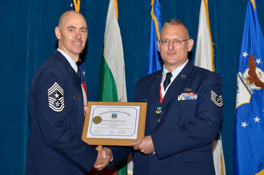 McGHEE TYSON AIR NATIONAL GUARD BASE, Tenn. - Tech. Sgt. Michael G. McFarland, right, from Otis ANGB, receives the distinguished graduate award for Noncommissioned Officer Academy Class 13-7 from Chief Master Sgt. Ronald C. Anderson, Jr., 1st Air Force (Air Forces Northern), Tyndall Air Force Base, Fla. here, Aug. 15, 2013. The distinguished graduate award is presented to students in the top 10 percent of the class.  It is based on objective and performance evaluations, demonstrated leadership, and performance as a team player. (U.S. Air National Guard photo by Master Sgt. Kurt Skoglund/Released)