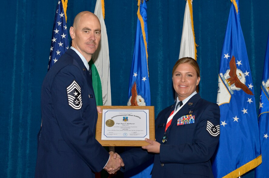McGHEE TYSON AIR NATIONAL GUARD BASE, Tenn. - Tech. Sgt. Sara C. Klobucar, right, from Scott AFB, receives the distinguished graduate award for Noncommissioned Officer Academy Class 13-7 from Chief Master Sgt. Ronald C. Anderson, Jr., 1st Air Force (Air Forces Northern), Tyndall Air Force Base, Fla. here, Aug. 15, 2013. The distinguished graduate award is presented to students in the top 10 percent of the class.  It is based on objective and performance evaluations, demonstrated leadership, and performance as a team player. (U.S. Air National Guard photo by Master Sgt. Kurt Skoglund/Released)