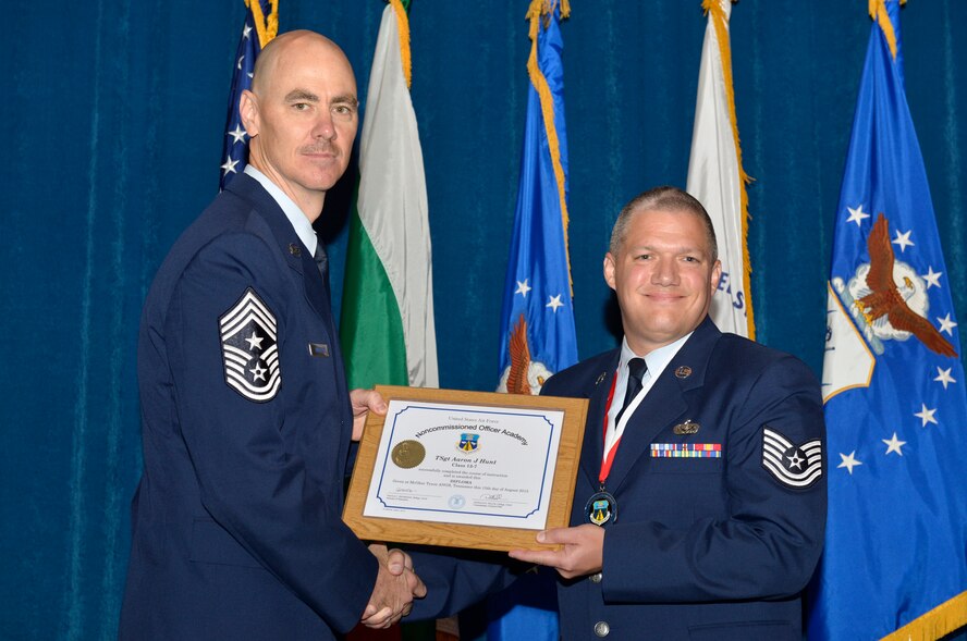 McGHEE TYSON AIR NATIONAL GUARD BASE, Tenn. - Tech. Sgt. Aaron J. Hunt, right, from Buckley AFB, receives the distinguished graduate award for Noncommissioned Officer Academy Class 13-7 from Chief Master Sgt. Ronald C. Anderson, Jr., 1st Air Force (Air Forces Northern), Tyndall Air Force Base, Fla. here, Aug. 15, 2013. The distinguished graduate award is presented to students in the top 10 percent of the class.  It is based on objective and performance evaluations, demonstrated leadership, and performance as a team player. (U.S. Air National Guard photo by Master Sgt. Kurt Skoglund/Released)