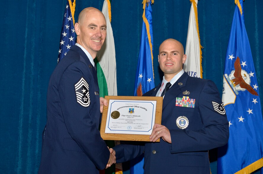 McGHEE TYSON AIR NATIONAL GUARD BASE, Tenn. - Tech. Sgt. Chad A. Hildreth, right, from Hanscom AFB, receives the distinguished graduate award for Noncommissioned Officer Academy Class 13-7 from Chief Master Sgt. Ronald C. Anderson, Jr., 1st Air Force (Air Forces Northern), Tyndall Air Force Base, Fla. here, Aug. 15, 2013. The distinguished graduate award is presented to students in the top 10 percent of the class.  It is based on objective and performance evaluations, demonstrated leadership, and performance as a team player. (U.S. Air National Guard photo by Master Sgt. Kurt Skoglund/Released)