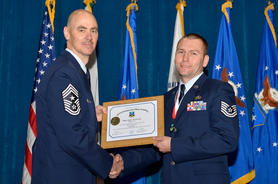 McGHEE TYSON AIR NATIONAL GUARD BASE, Tenn. - Tech. Sgt. Jason W. Fowler, right, from Scott AFB, receives the distinguished graduate award for Noncommissioned Officer Academy Class 13-7 from Chief Master Sgt. Ronald C. Anderson, Jr., 1st Air Force (Air Forces Northern), Tyndall Air Force Base, Fla. here, Aug. 15, 2013. The distinguished graduate award is presented to students in the top 10 percent of the class.  It is based on objective and performance evaluations, demonstrated leadership, and performance as a team player. (U.S. Air National Guard photo by Master Sgt. Kurt Skoglund/Released)