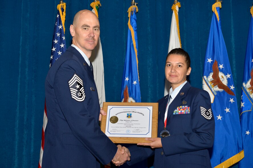 McGHEE TYSON AIR NATIONAL GUARD BASE, Tenn. - Tech. Sgt. Melissa D. Danner, right, from Scott AFB, receives the distinguished graduate award for Noncommissioned Officer Academy Class 13-7 from Chief Master Sgt. Ronald C. Anderson, Jr., 1st Air Force (Air Forces Northern), Tyndall Air Force Base, Fla. here, Aug. 15, 2013 The distinguished graduate award is presented to students in the top 10 percent of the class.  It is based on objective and performance evaluations, demonstrated leadership, and performance as a team player. (U.S. Air National Guard photo by Master Sgt. Kurt Skoglund/Released)