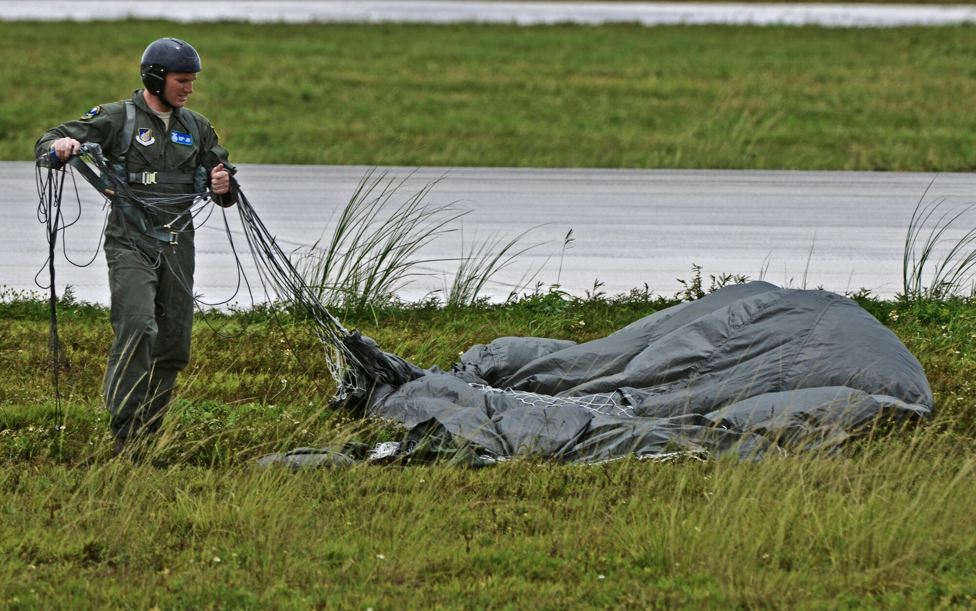 Staff Sgt. Daniel Guy, 736th Security Forces Squadron fire team leader, collects his parachute Aug. 21, 2013 after a static line jump on Andersen Air Force Base, Guam, flightline. As the integrated force protection element of the 36th Contingency Response Group, members of the 736th SFS provide a quick-response airborne capability that serves as an advance echelon team for contingency and humanitarian missions all over the Asia-Pacific region. (U.S. Air Force photo by Airman 1st Class Marianique Santos/Released)