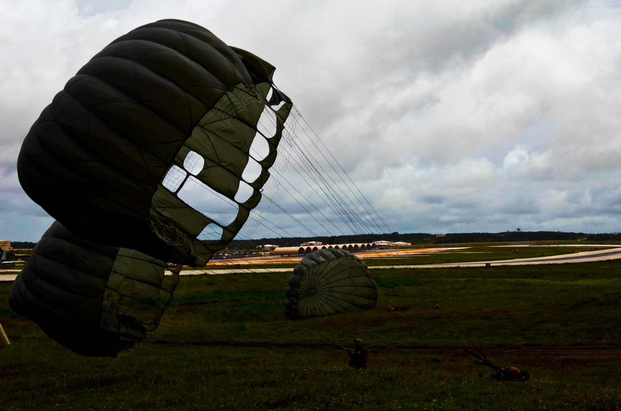 Members of the 736th Security Forces Squadron land on the drop zone Aug. 21, 2013, after a static line jump on the Andersen Air Force Base, Guam. As the integrated force protection element of the 36th Contingency Response Group, members of the 736th SFS provide a quick-response airborne capability that serves as an advance echelon team for contingency and humanitarian missions all over the Asia-Pacific region. (U.S. Air Force photo by Airman 1st Class Marianique Santos/Released)