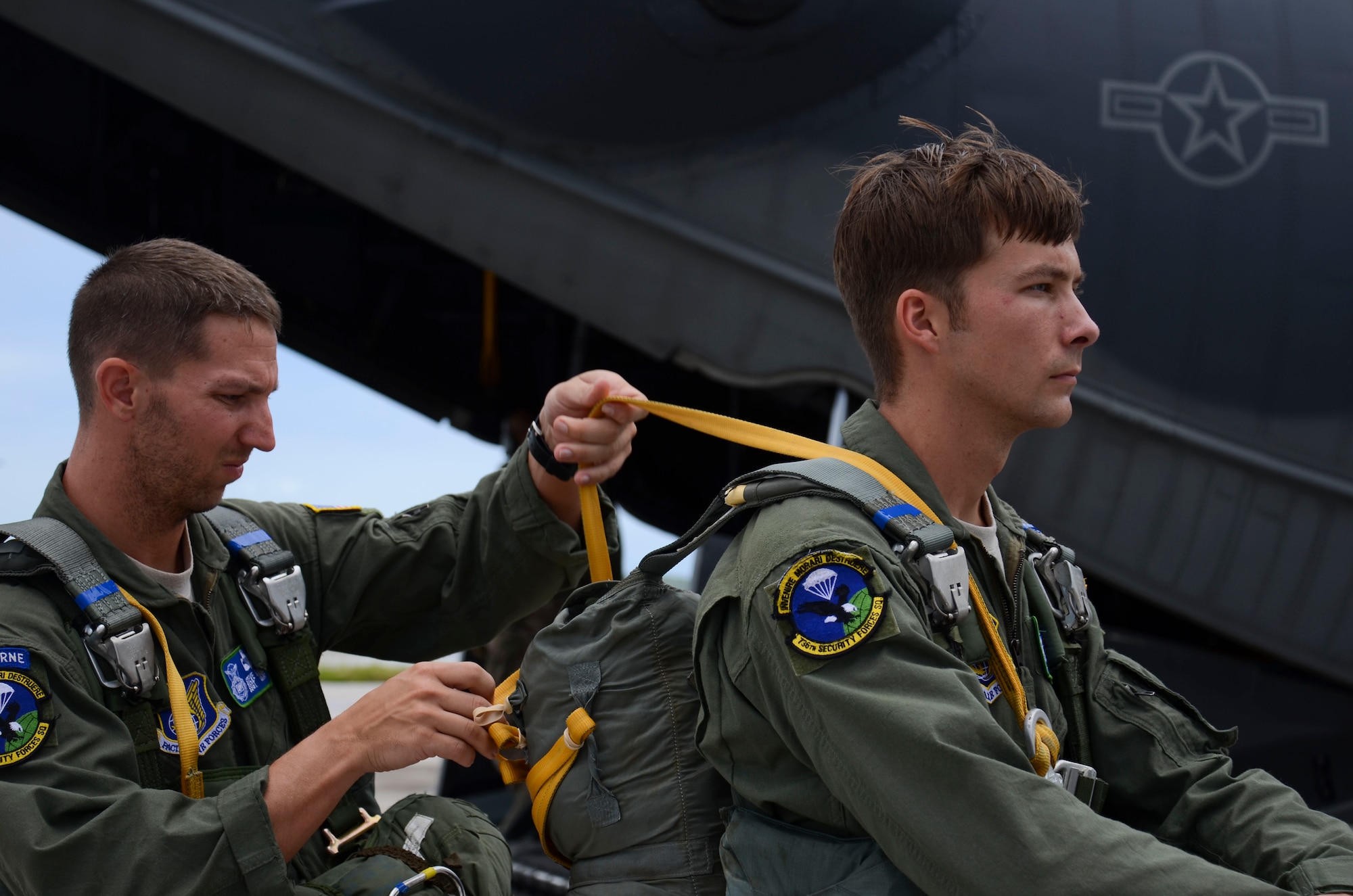 Staff Sgt. Stephen Baker, 736th Security Forces Squadron parachute program manager, assists Staff Sgt. Jacob Thompson, 736th SFS fire team leader and jumpmaster, in setting up his line Aug. 21, 2013, before boarding a C-130 Hercules at the Andersen Air Force Base, Guam flightline. Before the flight, the jumpmasters receive a briefing from the aircrew regarding the flight path, different jump scenarios and safety precautions. (U.S. Air Force photo by Airman 1st Class Marianique Santos/Released)