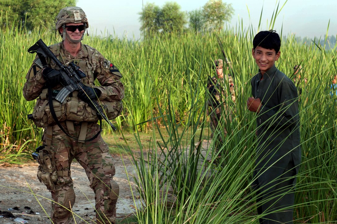 U.S. Army Spc. Michael Mizer shares a laugh with a local Afghan boy during a presence patrol around Forward Operating Base Fenty in Nangarhar province, Afghanistan, Aug. 22, 2013. Mizer, a medic, is assigned to the 1st Cavalry Division's 4th Squadron, 9th Cavalry Regiment, 2nd Armored Brigade Combat Team.