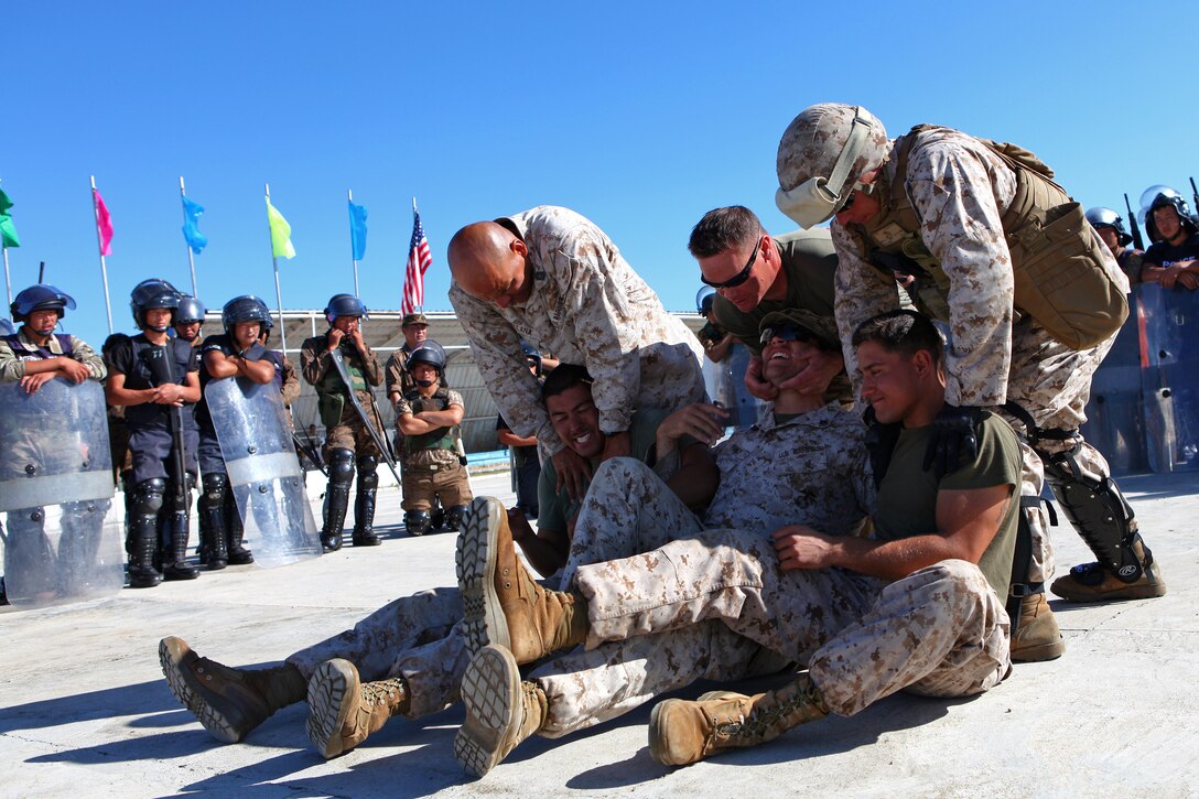 U.S. Marine nonlethal weapons instructors demonstrate apprehension techniques at the Five Hills Training Area, Mongolia, Aug. 25, 2013.