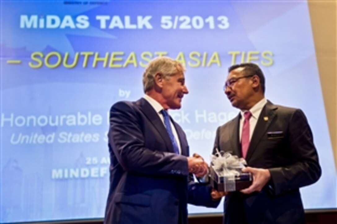 U.S. Defense Secretary Chuck Hagel accepts a gift from Malaysian Defense Minister Hishammuddin Tun Hussein after speaking at the Malaysian Institute of Defense and Security in Kuala Lumpur, Malaysia, Aug. 25, 2013.