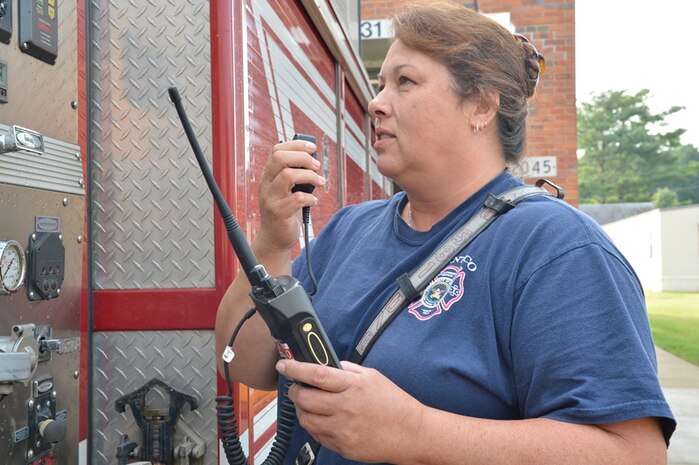 Tina Bryant, a firefighter with the Marine Corps Base Quantico, Va., Fire Department, demonstrates how her unit uses the enterprise-land mobile radio Aug. 27. Quantico completed its upgrade to the first-responder radio system, part of a Marine Corps-wide E-LMR project, in February 2013. 