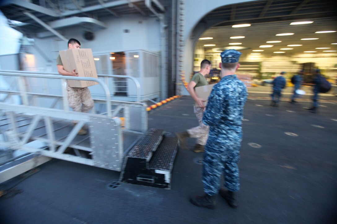 Marines with the 13th Marine Expeditionary Force load boxes into the USS Boxer at Naval Base San Diego, Aug. 23. More than 2,400 Marines and sailors with the 13th MEU departed for deployment with the Boxer Amphibious Ready Group.