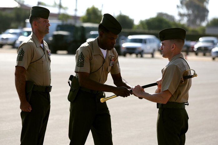 MARINE CORPS BASE CAMP PENDLETON, Calif. – Sergeant Maj. Clifford Wiggins, the former sergeant major of 3rd Assault Amphibian Battalion, hands a noncommissioned officer sword to Lt. Col. William Blanchard, the commanding officer of 3rd AABn., as Sgt. Maj. Michael P. Woods (left) takes over as battalion sergeant major during a relief and appointment ceremony here, Aug. 23, 2013. Relief and appointment ceremonies are one of the many traditions upheld in the Marine Corps today, which involves the passing of the noncommissioned officer sword from the outgoing sergeant major to the oncoming. The passing of the sword signifies the transfer of responsibility and entails the transfer of total accountability and authority, from one senior enlisted Marine to another. The sword thus continues as the personification of military tradition and is entrusted to those most responsible for maintaining it.