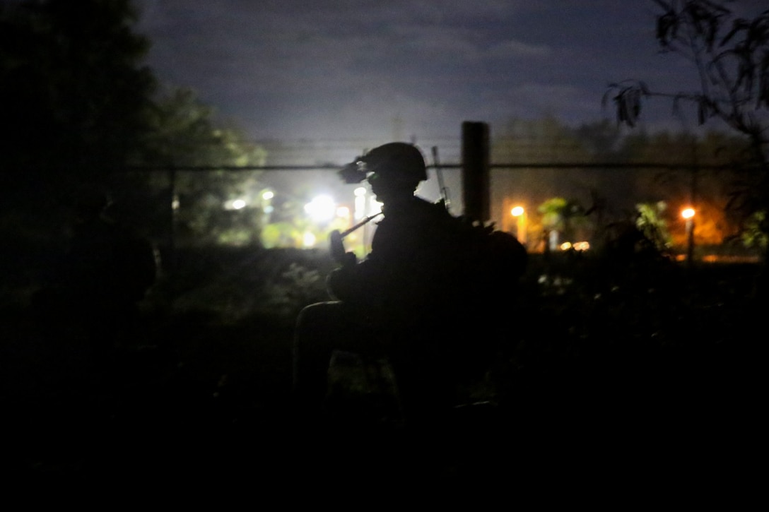 A Marine serving with with Alpha Company, 1st Reconnaissance Battalion, posts security during a night raid for a mission rehearsal exercise here, Aug. 19, 2013. The MRX tested the Marines ability to organize and move within their fire teams while coordinating with their command element.