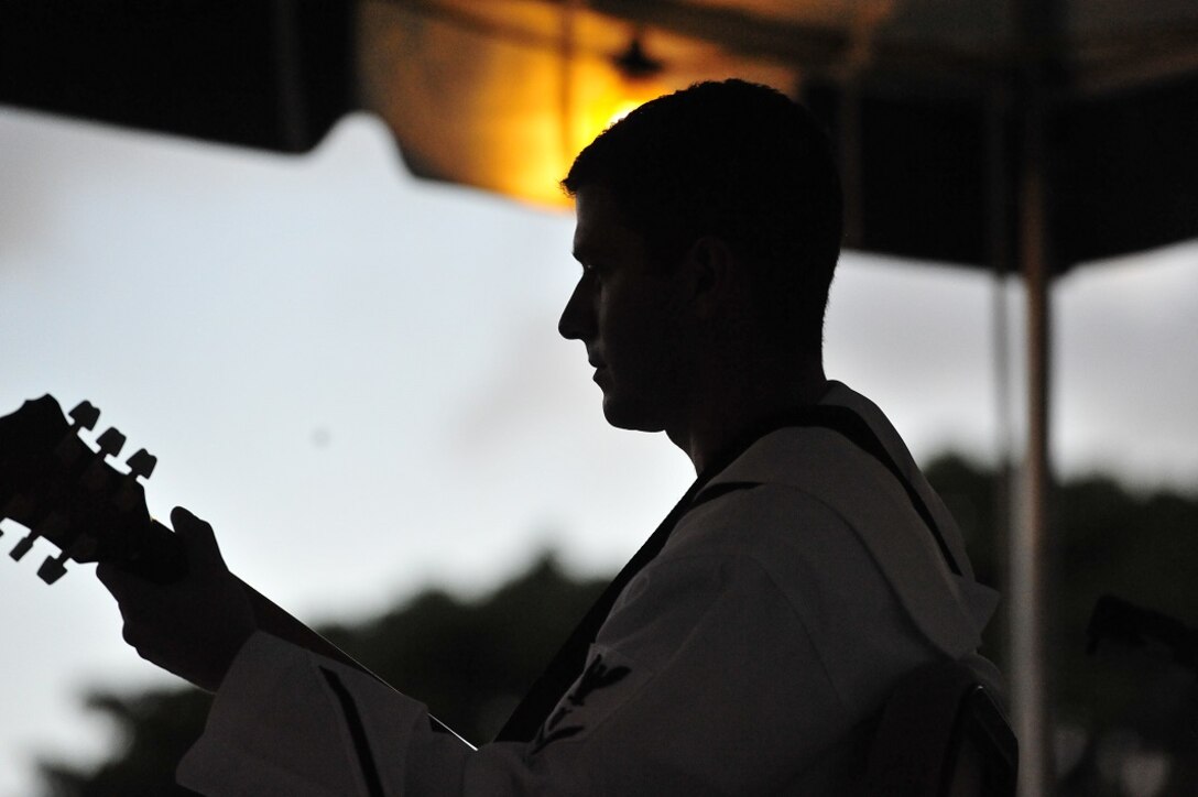 JOINT BASE PEARL HARBOR-HICKAM, Hawaii -- Musician 3rd Class Travis Smilen, Navy Fleet Band, plays a solo as the sun is setting on Joint Base Pearl Harbor-Hickam, Hawaii, Aug. 23, 2013. The United States Air Force Band of the Pacific-Hawaii and the Navy Fleet Band performed two joint concerts over the summer to an audience of about 1,500 people. The joint concerts build strong relations between the Navy and Air force, while narrowing the gap between the Hickam and Pearl Harbor sides of the base. 

(US Air Force Photo/ SSgt Courtney Clifford/ released)