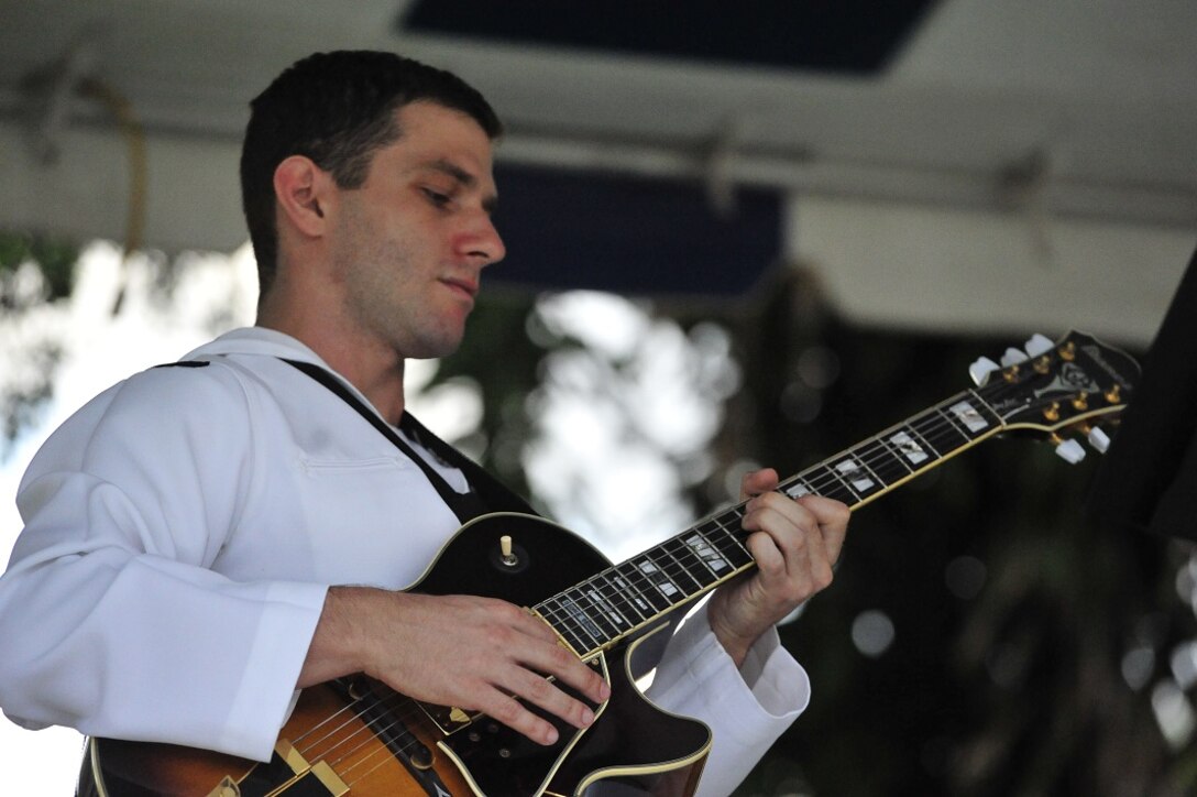 JOINT BASE PEARL HARBOR-HICKAM, Hawaii -- Musician 3rd Class Travis Smilen, Navy Pacific Fleet Band, solos on jazz guitar during the concert on Joint Base Pearl Harbor-Hickam, Hawaii, Aug. 23, 2013. The United States Air Force Band of the Pacific-Hawaii and the Navy Fleet Band performed two joint concerts over the summer to an audience of about 1,500 people. The joint concerts build strong relations between the Navy and Air force, while narrowing the gap between the Hickam and Pearl Harbor sides of the base. 

(US Air Force Photo/ SSgt Courtney Clifford/ released)