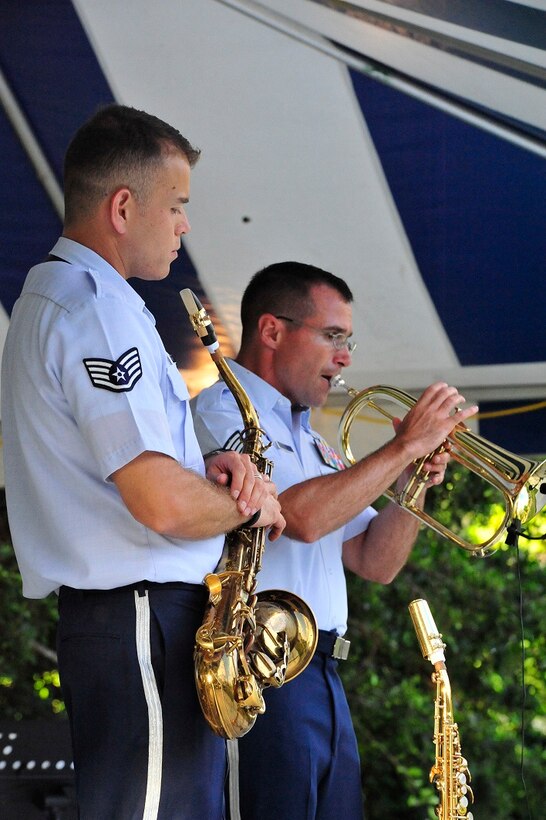 JOINT BASE PEARL HARBOR-HICKAM, Hawaii -- Technical Sergeant David Diamond, Band of the Pacific-Hawaii, background, solos on the cornet during a joint band concert at Joint Base Pearl Harbor-Hickam, Hawaii, Aug. 23, 2013. The United States Air Force Band of the Pacific-Hawaii and the Navy Fleet Band performed two joint concerts over the summer to an audience of about 1,500 people. The joint concerts build strong relations between the Navy and Air force, while narrowing the gap between the Hickam and Pearl Harbor sides of the base. 

(US Air Force Photo/ SSgt Courtney Clifford/ released)