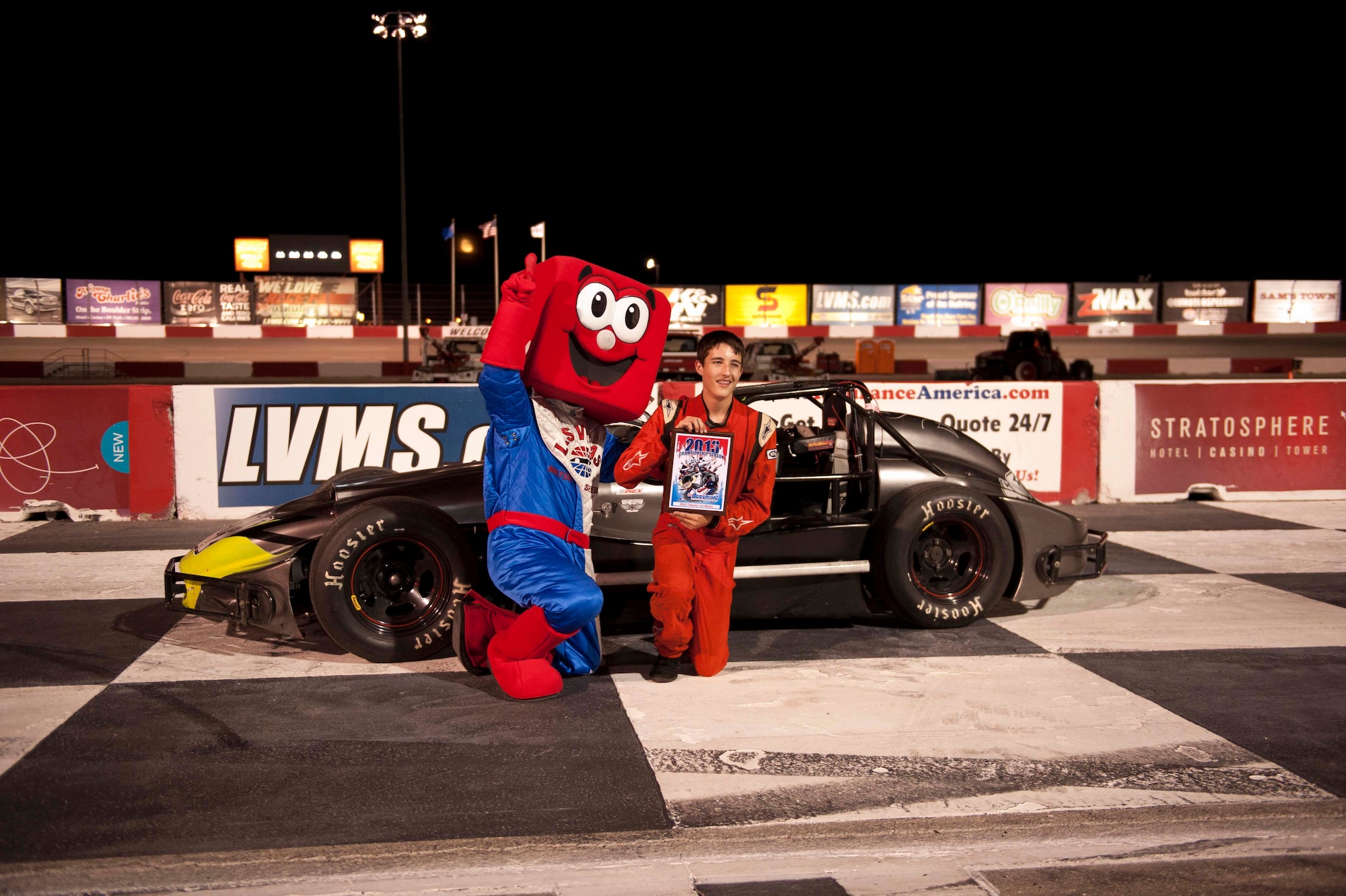 Ian Anderson poses with the Las Vegas Motor Speedway’s mascot in front of his Thunder Roadster Aug. 24, 2013, at the Las Vegas Motor Speedway Bullring, Las Vegas. Ian currently has an undefeated record of 21-0 at the Las Vegas Motor Speedway’s Bullring. Ian is the son of Master Sgt. Cristy Anderson, 53rd Test and Evaluation Group first sergeant. (U.S. Air Force photo by Airman 1st Class Timothy Young)