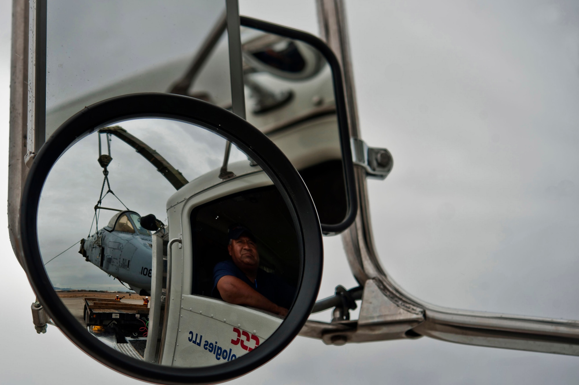 Gilbert Vigil, a truck driver, watches as members from the 57th Maintenance Squadron crash recovery team guide an A-10 Thunderbolt II fuselage onto his flatbed truck Aug. 26, 2013, at Nellis Air Force Base, Nev. The fuselage was taken to the NTTR where it will be used for pilots to lase targets during training missions. (U.S. Air Force photo by Senior Airman Daniel Hughes)