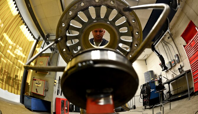 Staff Sgt. Alex Aguayo 6th Maintenance Squadron aircraft metals technician inspects a newly fabricated wheel workstation, Aug 20, 2013 at MacDill Air Force Base, Fla. Aguayo co-engineered a stand to hold the wheel, which reduces the man hours needed to paint by 26 man-hours per set. (U.S. Air Force photo/Staff Sgt. Brandon Shapiro)