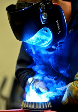 Staff Sgt. Alex Aguayo 6th Maintenance Squadron aircraft metals technician welds together a rotational plate he designed for a paint work station, Aug 22, 2013 at MacDill Air Force Base, Fla. Aguayo is one of two Airmen that co-engineered a way to centrifugally mount a KC-135’s nose and main landing wheel on a rotating base, which reduces a wheel’s paint process by 50 percent. (U.S. Air Force photo/Staff Sgt. Brandon Shapiro)