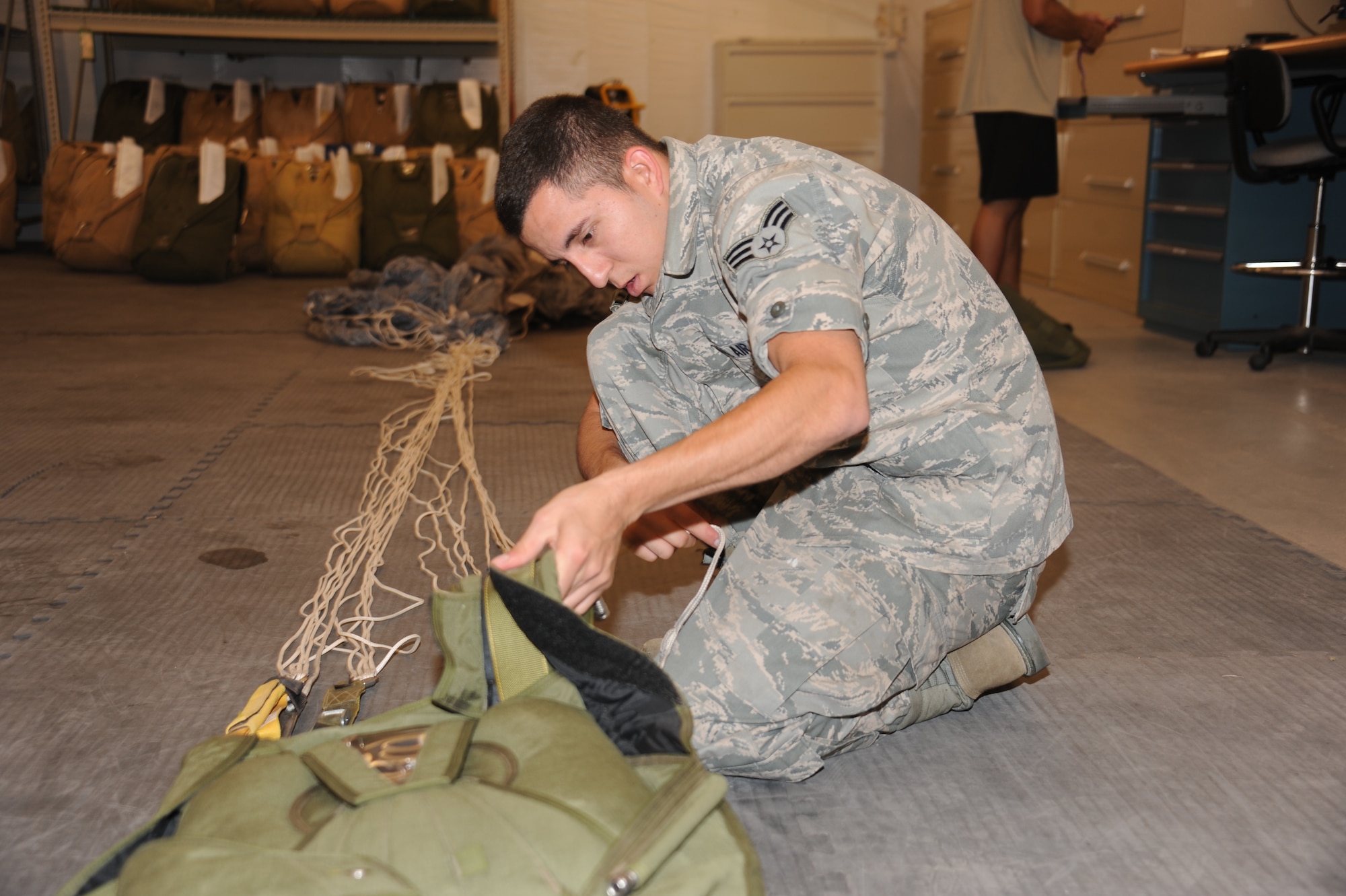 Senior Airman Jeremy Molly, 342nd Training Squadron, Detachment 1, inspects and packs a freefall parachute. (Photo by Dennis Carlson)