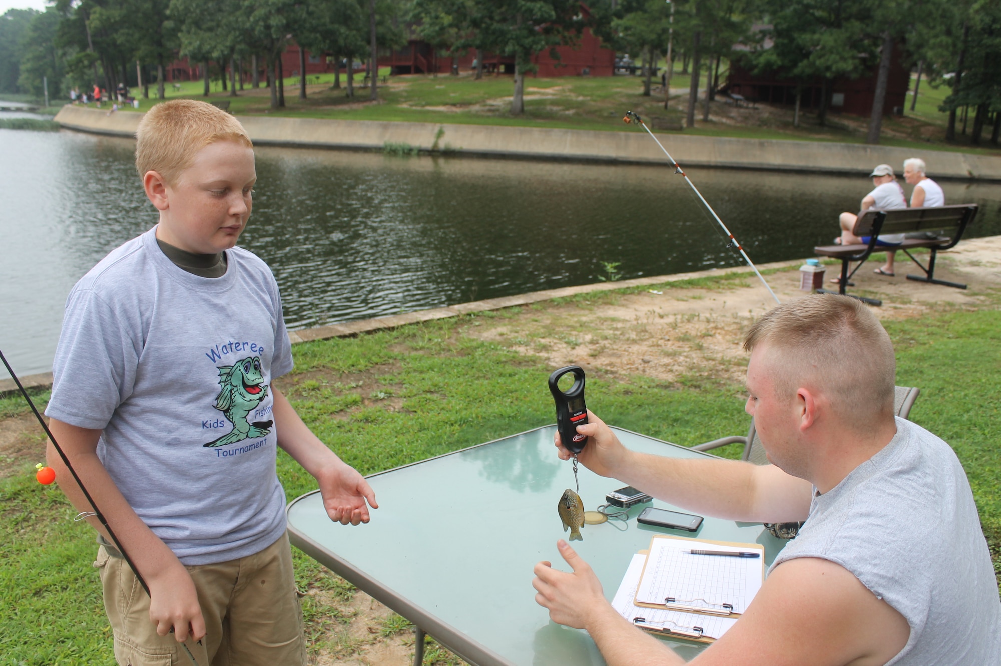 Airman 1st Class Caleb Sowders, 20th Security Forces Squadron installation entry controller, weighs a fish caught by one of the children during the 7th Annual End of Summer Kids Fishing Tournament at the Wateree Recreation Area, S.C., Aug. 24, 2013. (Courtesy photo by Curt Marshall)