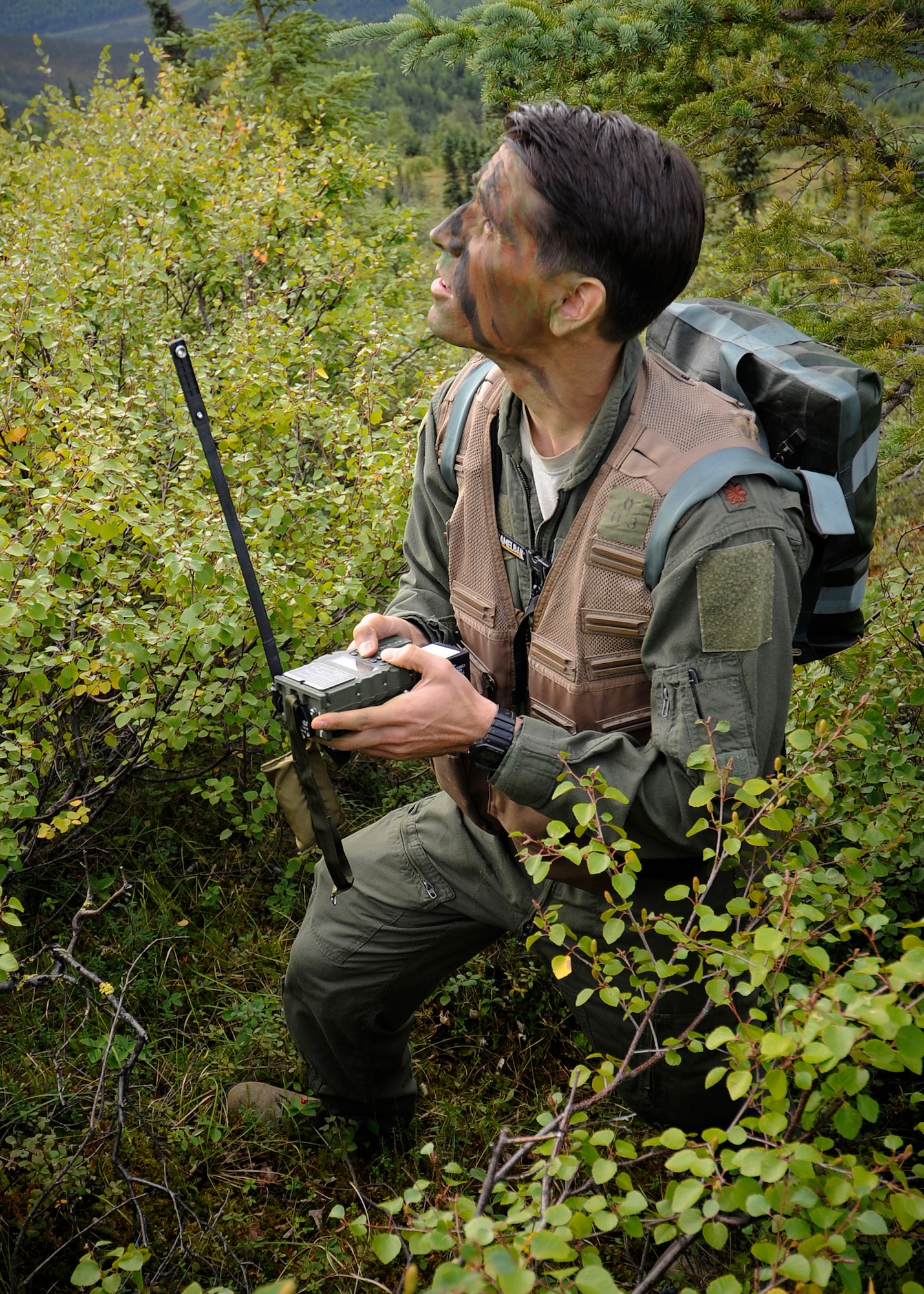 Maj. Michael Cahill, 353rd Combat Training Squadron director of operations, sends location information to friendly forces during RED FLAG-Alaska 13-3, Aug. 22, 2013, Eielson Air Force Base, Alaska. Cahill was acting as a downed pilot while his position was defended by several friendly aircraft. (U.S. Air Force photo by Senior Airman Shawn Nickel/Released)