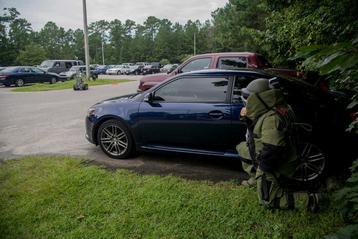 Staff Sgt. Aaron Clark, 628th Civil Engineer Squadron explosive ordnance disposal technician, kneels at a safe distance  as X-rays are taken of the simulated suspect device during an exercise Aug. 22, 2013 at Joint Base Charleston - Weapons Station, S.C. The scenario was one of many that tested JB Charleston to perform their duties under heightened security conditions during a routine security exercise. (U.S. Air Force photo/Tech. Sgt. Rasheen Douglas)