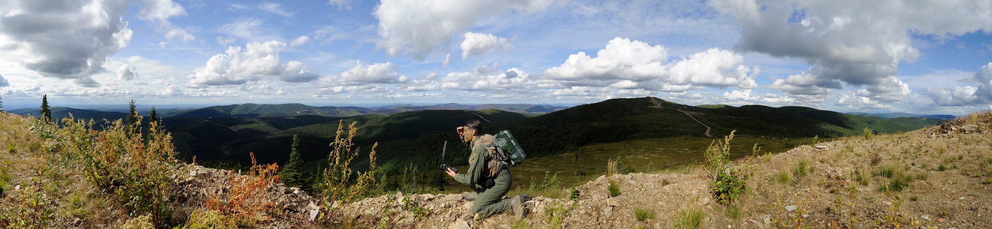 Maj. Michael Cahill, 353rd Combat Training Squadron director of operations, sends location information to friendly forces and gains line of sight during RED FLAG-Alaska 13-3, Aug. 22, 2013, Eielson Air Force Base, Alaska. Cahill was acting as a downed pilot while his position was defended by several friendly aircraft. (U.S. Air Force photo illustration by Senior Airman Shawn Nickel/Released)