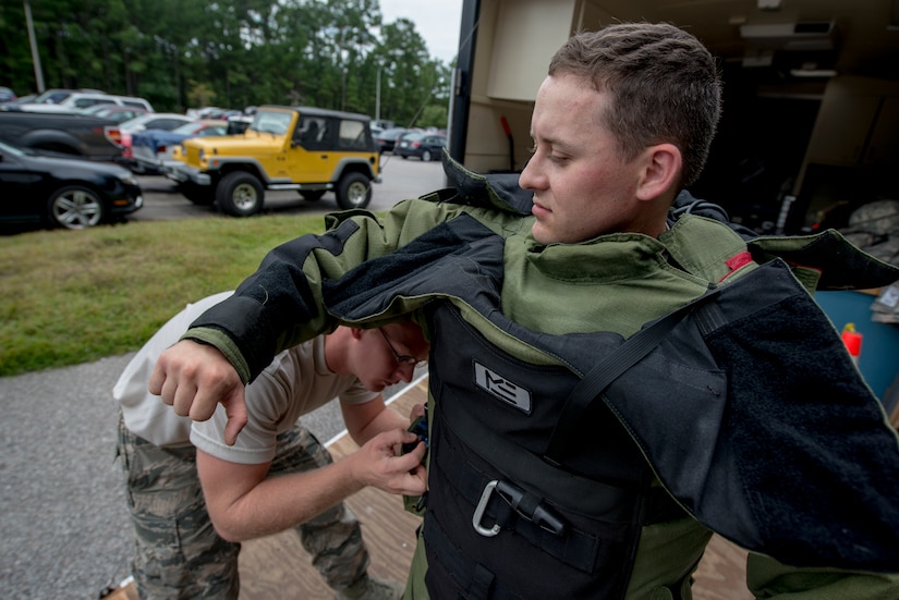 Senior Airman Robert Hardy, helps Staff Sgt. Aaron Clark with donning on his bomb suit during an anti-terrorism exercise on Aug. 22, 2013, at Joint Base Charleston - Weapons Station.  Both are explosive ordnance disposal technicians assigned to the 628th Civil Engineer Squadron. The scenario was one of many that tested JB Charleston to perform their duties under heightened security conditions during a routine security exercise. (U.S. Air Force photo/Tech. Sgt. Rasheen Douglas)