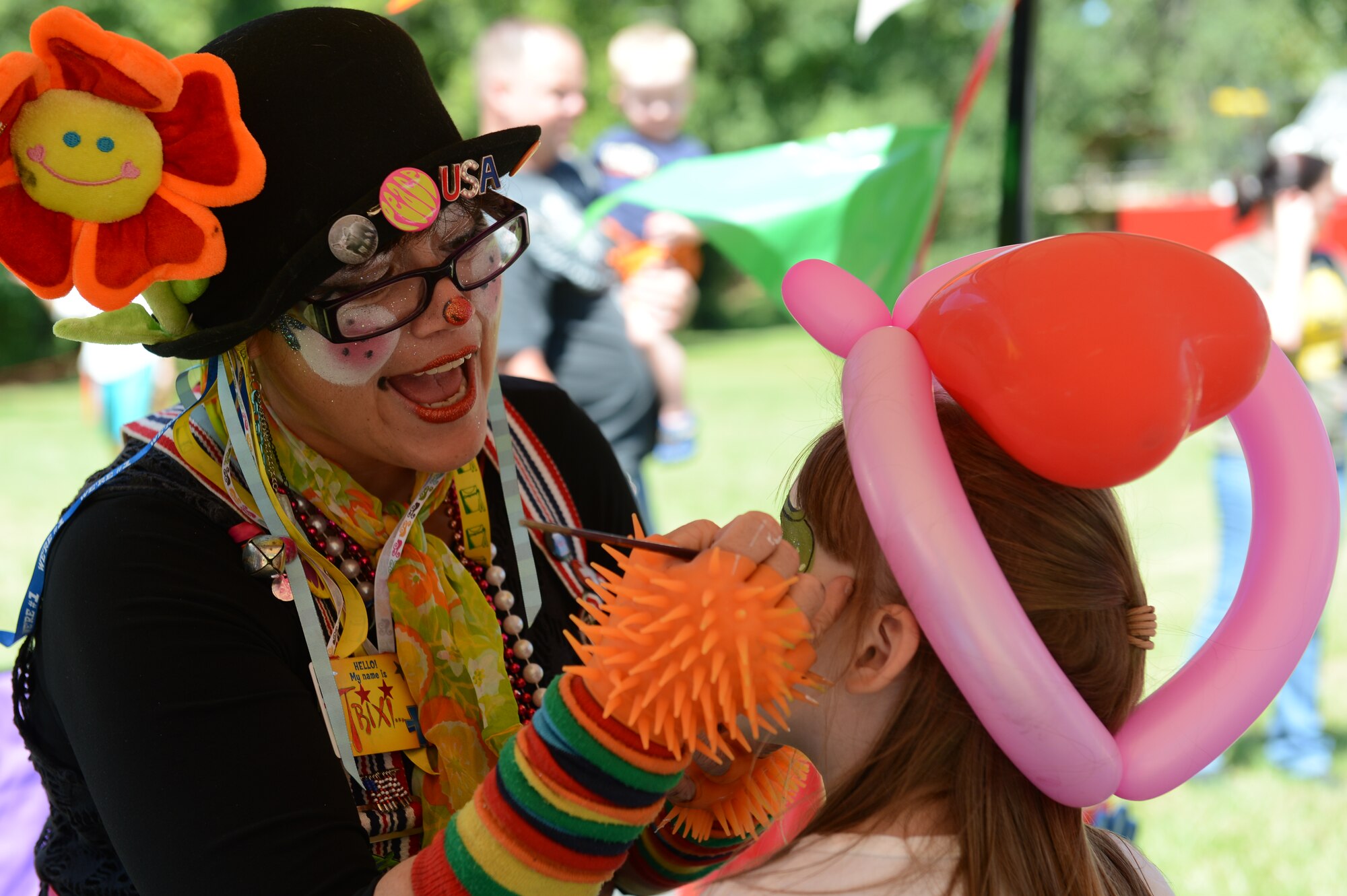 Patricia “Trixi” Huth, a member of Lowcountry Party Animals, paints the face of a child during the Shawsome Mega Sunday event at Shaw Air Force Base, S.C., Aug. 25, 2013. Shawsome was a free fair hosted by the chapel to promote base morale. In addition to clowns who face painted and made balloon creations, there was also a petting zoo with sheep, horses, donkeys and rabbits. (U.S. Air Force photo by Airman 1st Class Krystal M. Jeffers/Released)