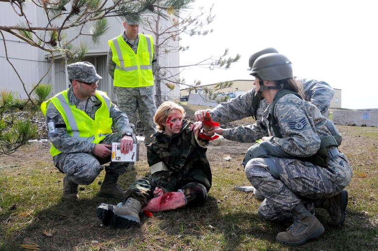 Staff Sgt. Kathryn M. Pierce, a member of the 148th Fighter Wing Command Post, treats Staff Sgt. Darin A. Glavan, a simulated casualty during a Readiness Exercise (RE) at the 148th Fighter Wing May 17, 2013.  The Air Combat Command (ACC) Inspector General team evaluated the 148FW during a Readiness Inspection (RI), Aug. 22-24, 2013, the wing received an overall grade of excellent.  (U.S. Air National Guard photo by Tech. Sgt. Scott G. Herrington/Released)