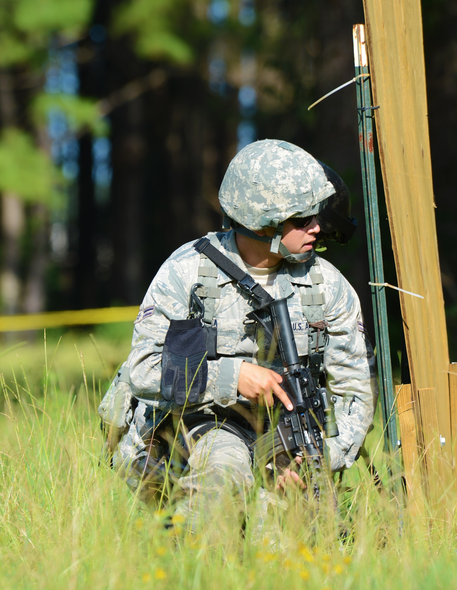U.S. Air Force Airman 1st Class Mike Garza, 20th Security Forces installation entry controller, takes cover behind a wooden barrier before covering his partner during a shoot, move and communicate exercise at Shaw Air Force Base, S.C., Aug. 21, 2013. Every six months, 20th SFS Airmen are required to complete M4 carbine sufficiency training while learning to work as a team. (U.S. Air Force photo by Senior Airman Tabatha Zarrella/Released)  
