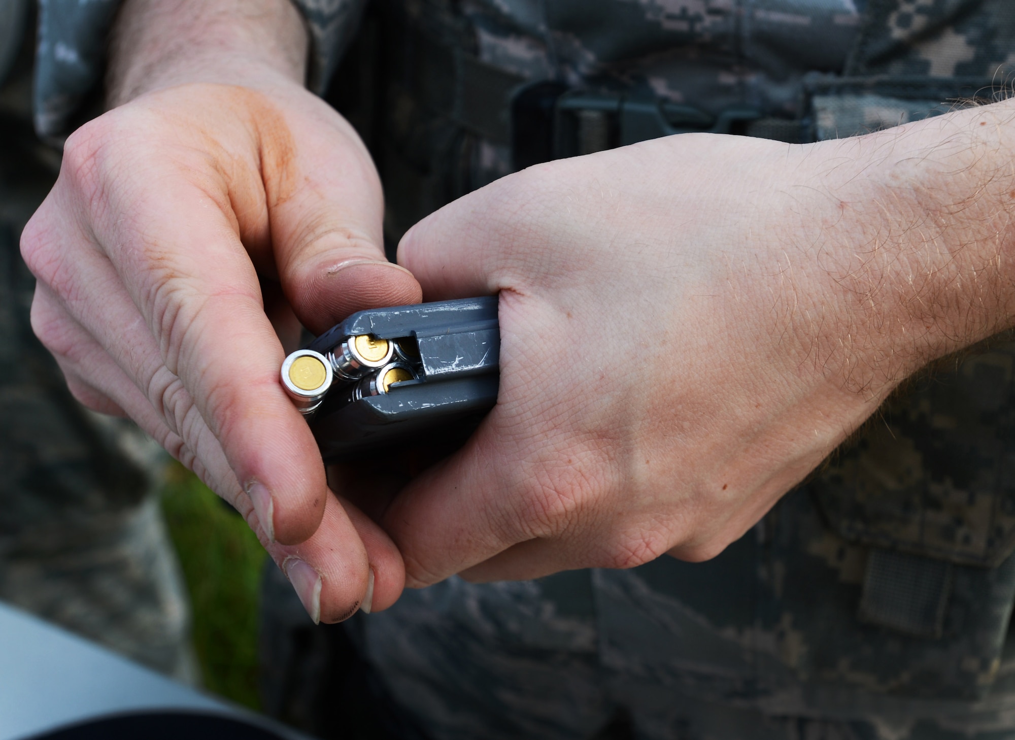 A U.S. Air Force 20th Security Forces Squadron Airman prepares for a shoot, move and communicate exercise by loading his weapons with simulation 5.56 rounds at Shaw Air Force Base, S.C., Aug. 21, 2013. Every six months, 20th SFS Airmen are required to complete M4 carbine sufficiency training while learning to work as a team. (U.S. Air Force photo by Senior Airman Tabatha Zarrella/Released)
