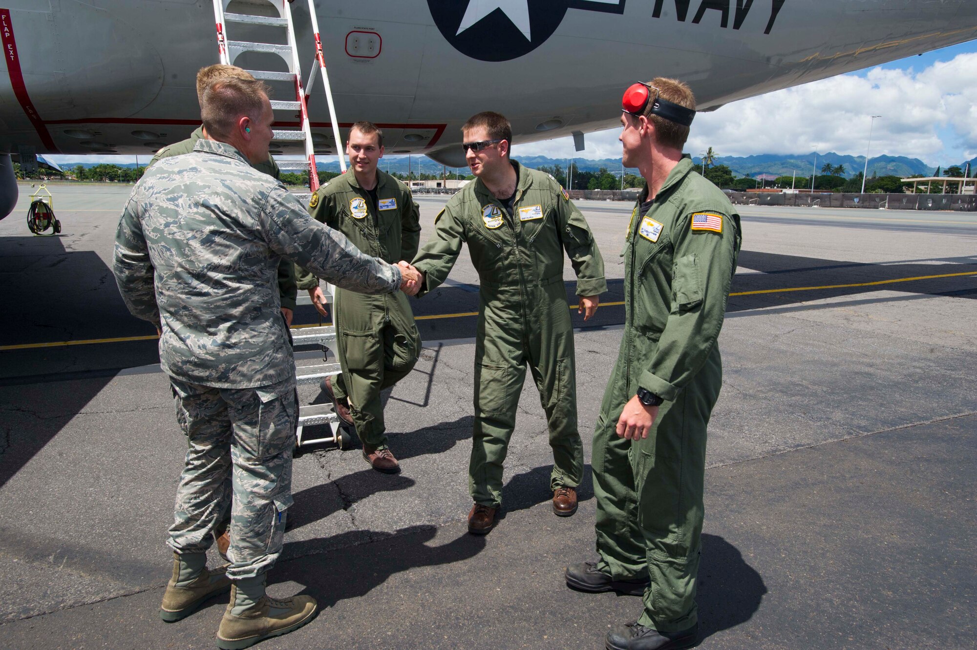 Col. Johnny Roscoe, 15th Wing commander, greets the flight crew of a P-3 Orion shortly after their arrival on the flightline at Joint Base Pearl Harbor-Hickam, Hawaii, Aug. 23, 2013. More than 175 Navy maintainers and crew members are temporarily working here in support of the aircraft, which have relocated to due to maintenance on the Marine Corps Base Hawaii flightline. (U.S. Air Force photo/Staff Sgt. Terri Paden)