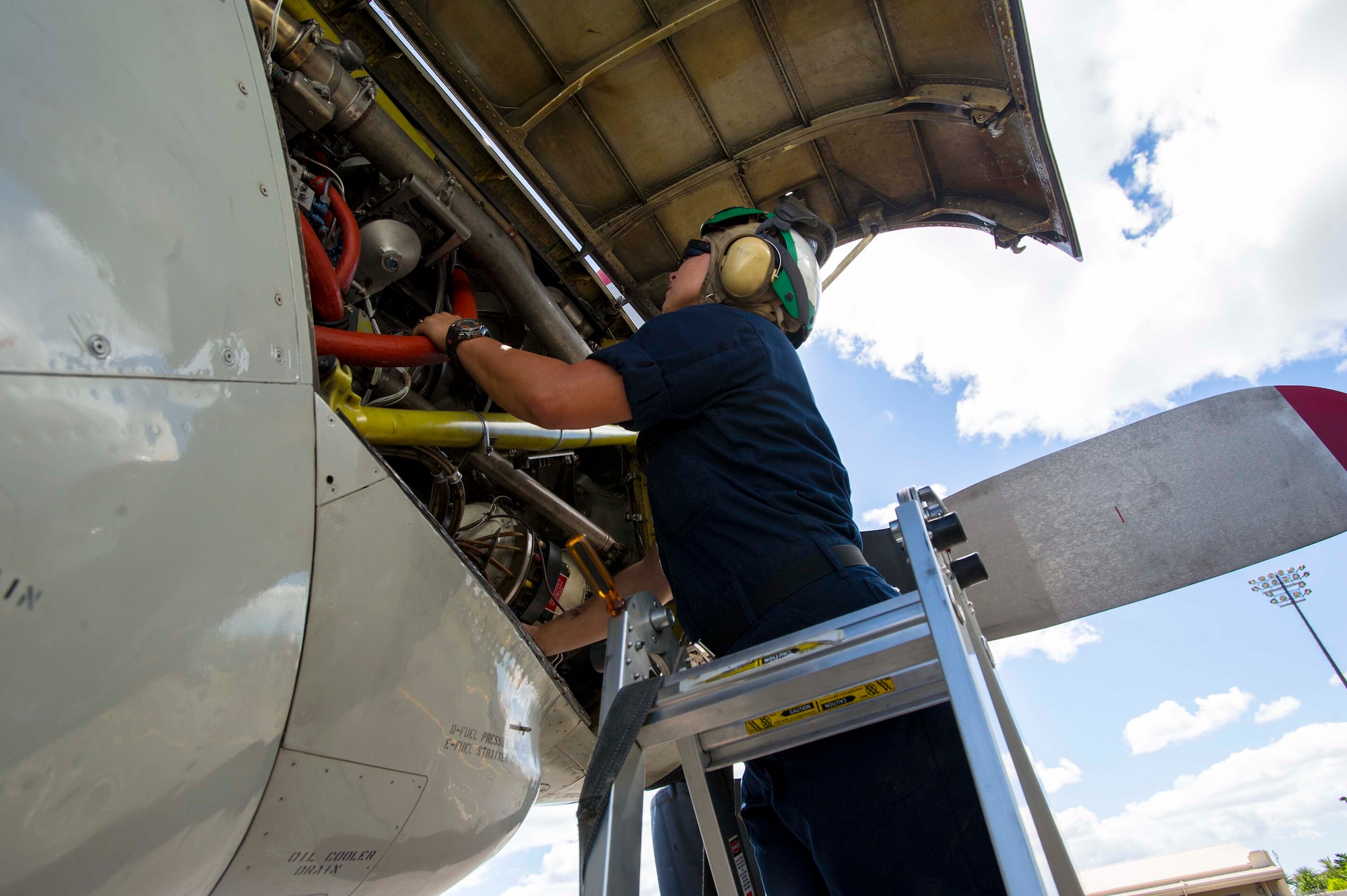 Navy Petty Officer 3rd Class Brittney Mueller, Patrol Squadron Nine aviation machinist mate 3rd Class, performs a daily inspection on a P-3 Orion shortly after its landing at Joint Base Pearl Harbor-Hickam, Hawaii, Aug. 23, 2013. The P-3 is a four-engine turboprop anti-submarine and maritime surveillance aircraft that has been used by the Navy for more than 50 years. (U.S. Air Force photo/Staff Sgt. Terri Paden)