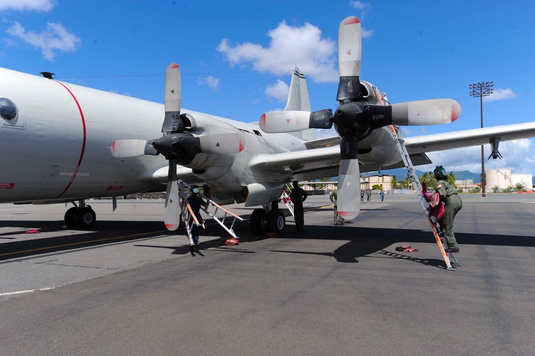 Maintainers assigned to Patrol Squadron Nine perform an aircraft inspection on a P-3 Orion after it lands at Joint Base Pearl Harbor-Hickam, Hawaii, Aug. 23, 2013. More than 175 Navy maintainers and crew members are temporarily working here in support of the aircraft, which have relocated to due to maintenance on the Marine Corps Base Hawaii flightline. (U.S. Air Force photo/Staff Sgt. Terri Paden)
